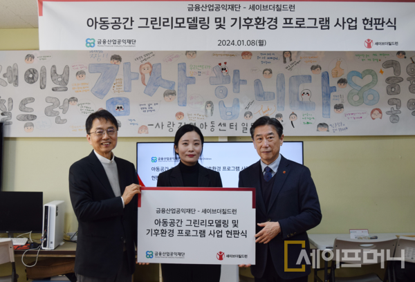 ▲ 박준식 금융산업공익재단 이사장(왼쪽)이 8일 충남 논산 사랑지역아동센터에서 아동공간 그린리모델링과 기후환경 프로그램 사업 현판식을 하고 있다. ⓒ 금융산업공익재단