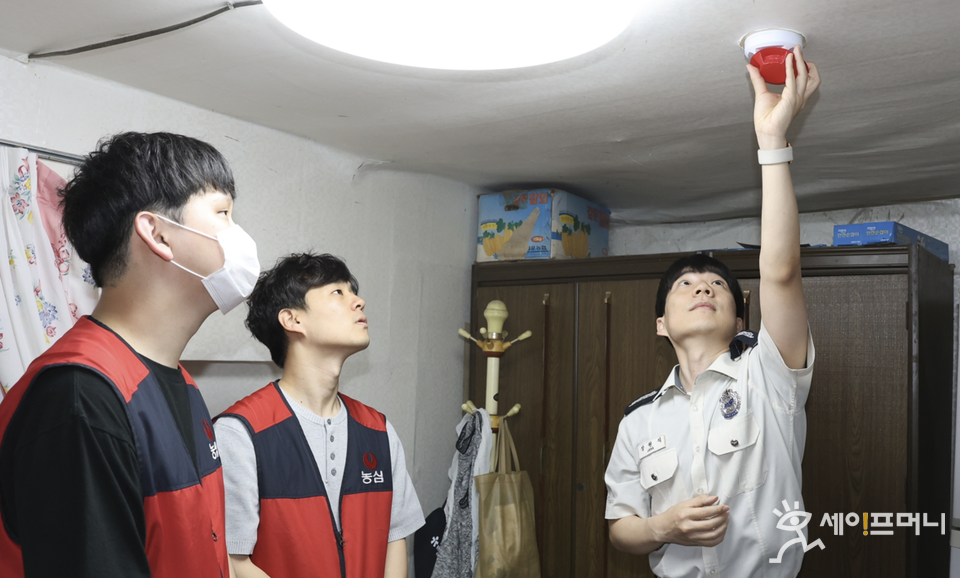 ▲ 농심이 지원한 화재경보기를 소방청 관계자가 취약계층 가구에 설치하고 있다. ⓒ 농심